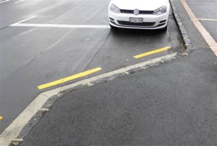 What is the meaning of a yellow broken line painted on the road near the KERB?